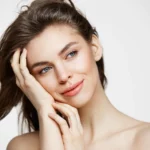 beautiful-naked-young-woman-with-perfect-clean-skin-smiling-touching-hair-white-wall-facial-treatment_176420-13992